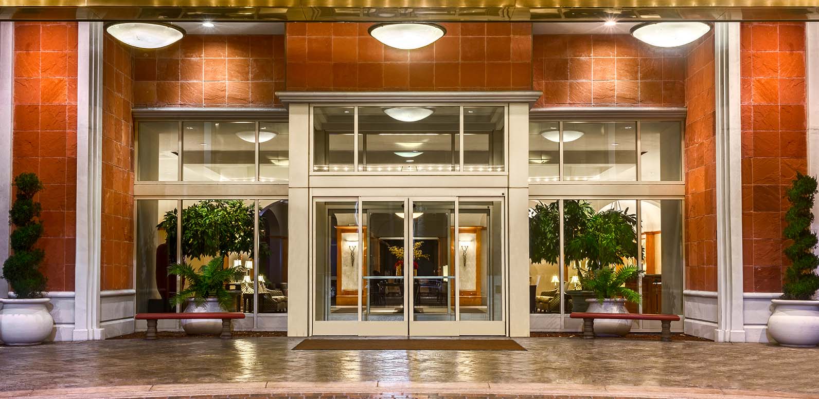 Entrance to Hilton Santa Clara illuminated at night, showcasing the hotel's grand front doors and welcoming lobby.