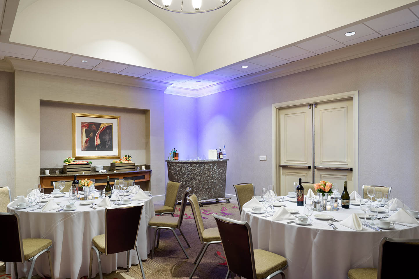 Coastal Ballroom at Hilton Santa Clara set up in banquet style with round tables, chairs, and formal place settings; accommodates up to 125 guests